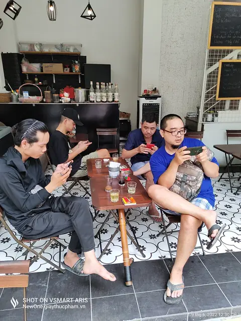 People relaxing with smartphones at a cafe in Hanoi